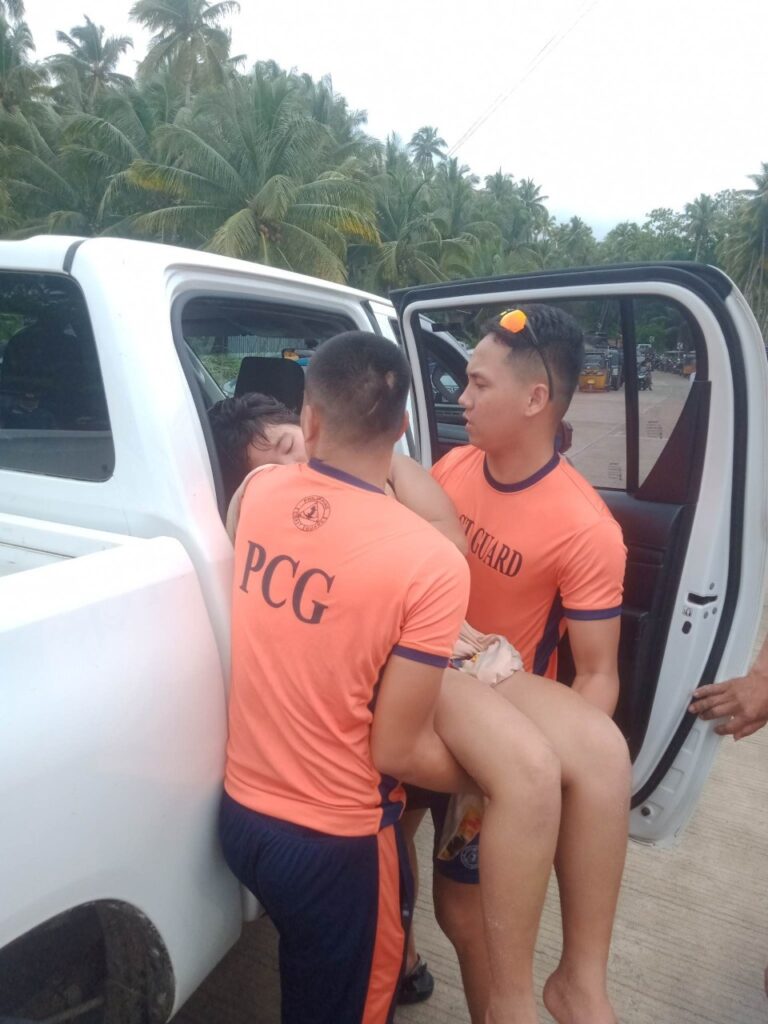 Two of the Coast Guard Personnel who is rescuing the woman and putting her in a vehicle